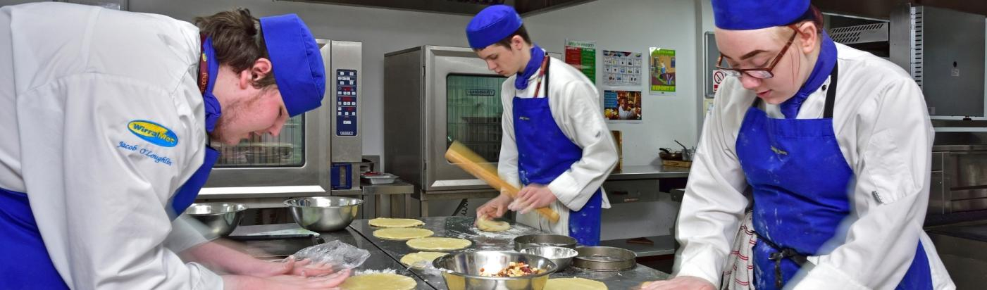 Three WMC Professional Cookery Advanced Diploma students working inside hospitality classroom