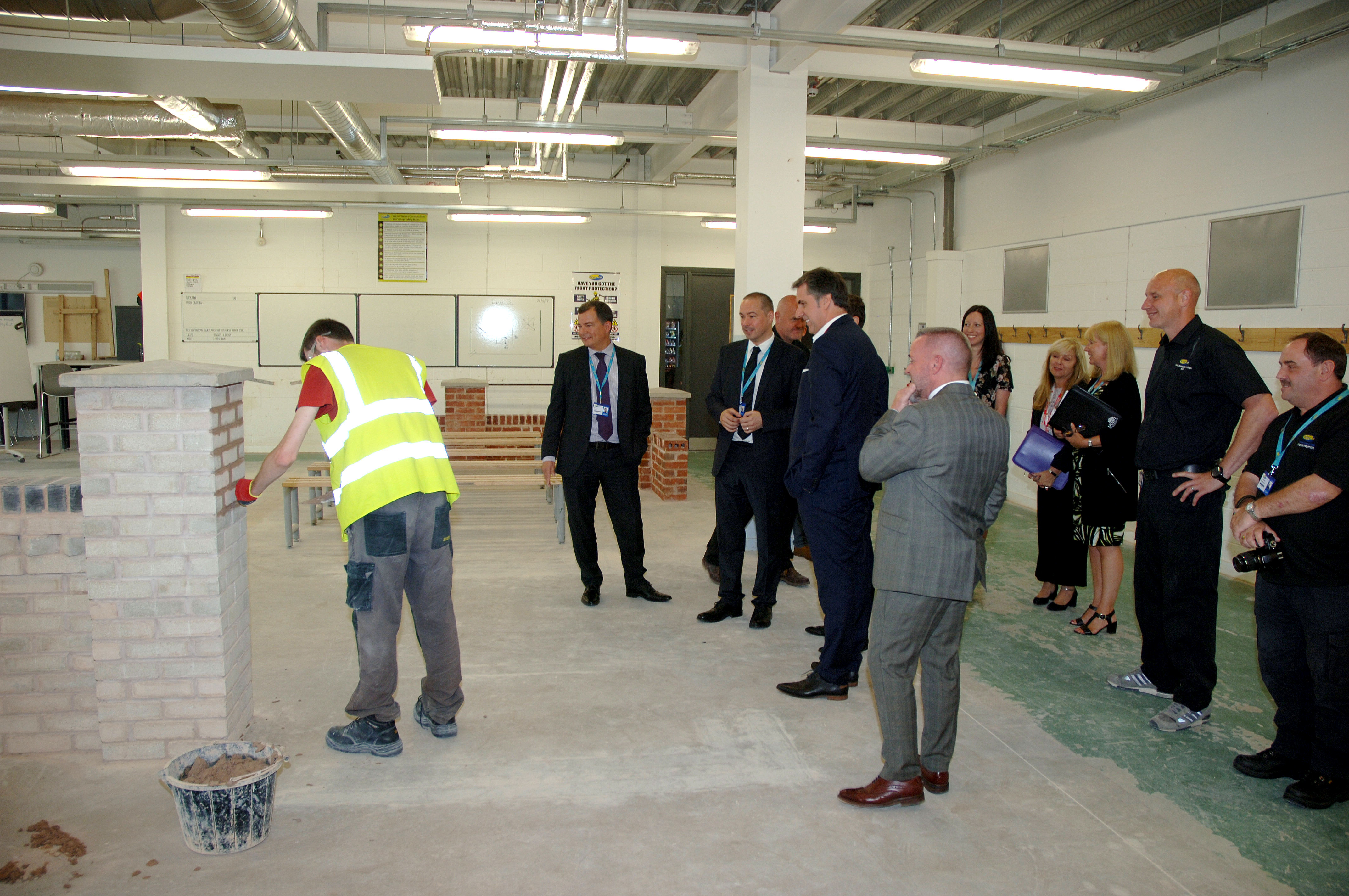 Metro Mayor Steve Rotheram and Cabinet Secretary Ken Skates watching a Student wearing Hi-Vis Jacket at Wirral Waters campus