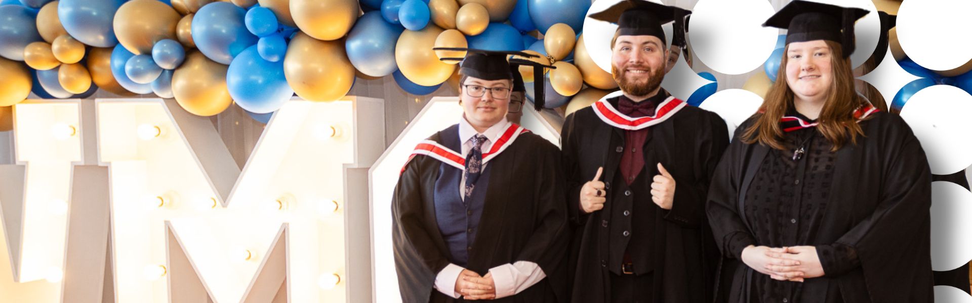 Wirral Met graduates stood in front a balloon backdrop