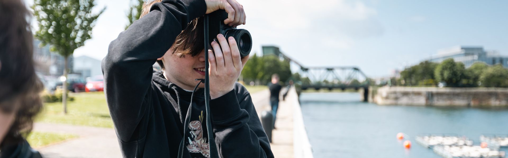 Wirral Met HND Photography students aiming cameras in front of a white background