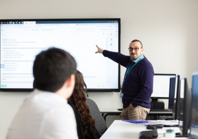 Male Part Time Accounting And Professional Studies Student Sat In A Classroom Wearing Glasses