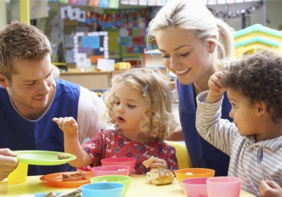 Three Female Part Time Childcare And Early Years Education Students Standing Inside Classroom Holding Baby Models