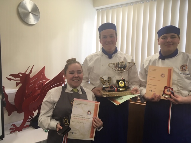 three successful hospitality and catering students holding their awards from chef competition