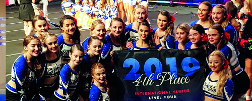 cheerleading team together posing next to a fourth place sign in Florida